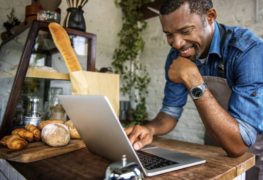 Man using laptop to read up on trends.